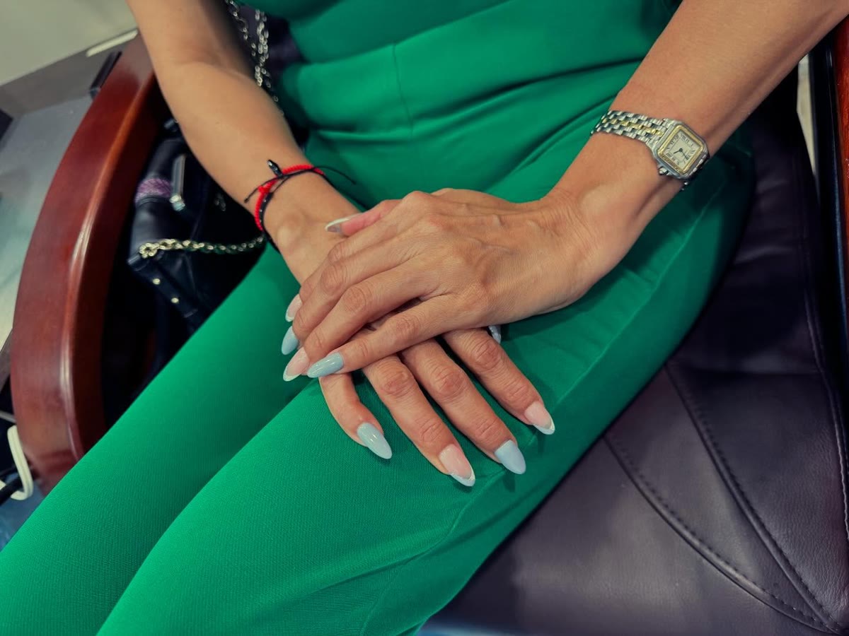 Almond-shaped nude set with a high-gloss finish, worn with a green dress.